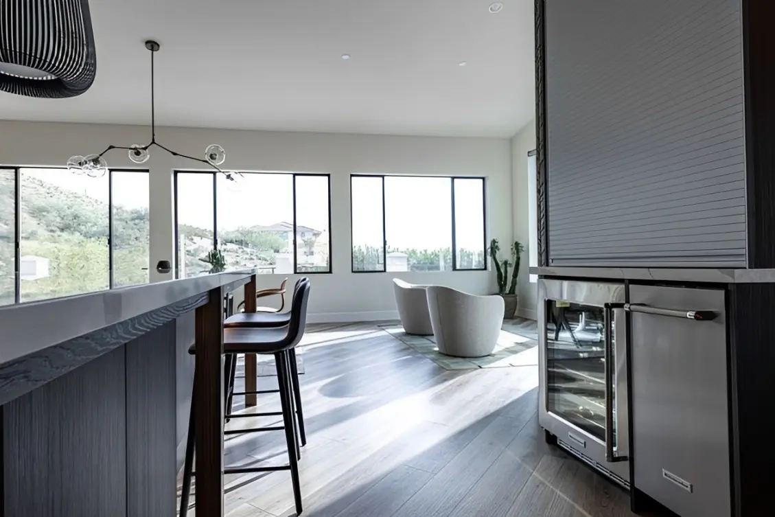 Modern kitchen with large windows and seating.