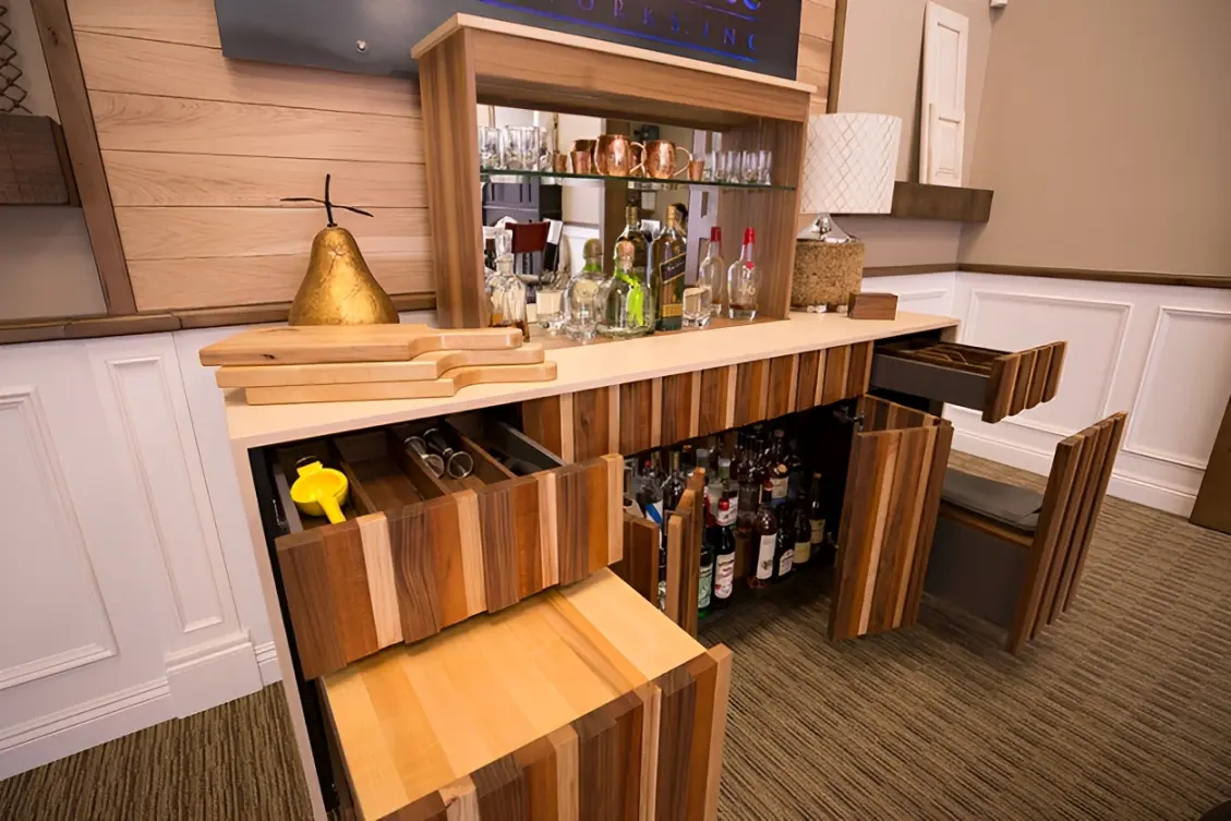 Modern wooden bar with liquor bottles displayed.